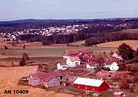 Flyfoto av grden Oraug<br>Grdstun med mange hus.<br>Vi ser Jutulbua omtrent midt i bildet til hyre